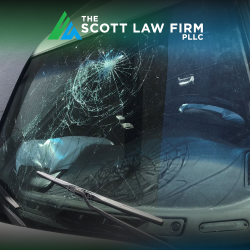 A smashed windshield after a car accident, indicating a head injury could have been sustained